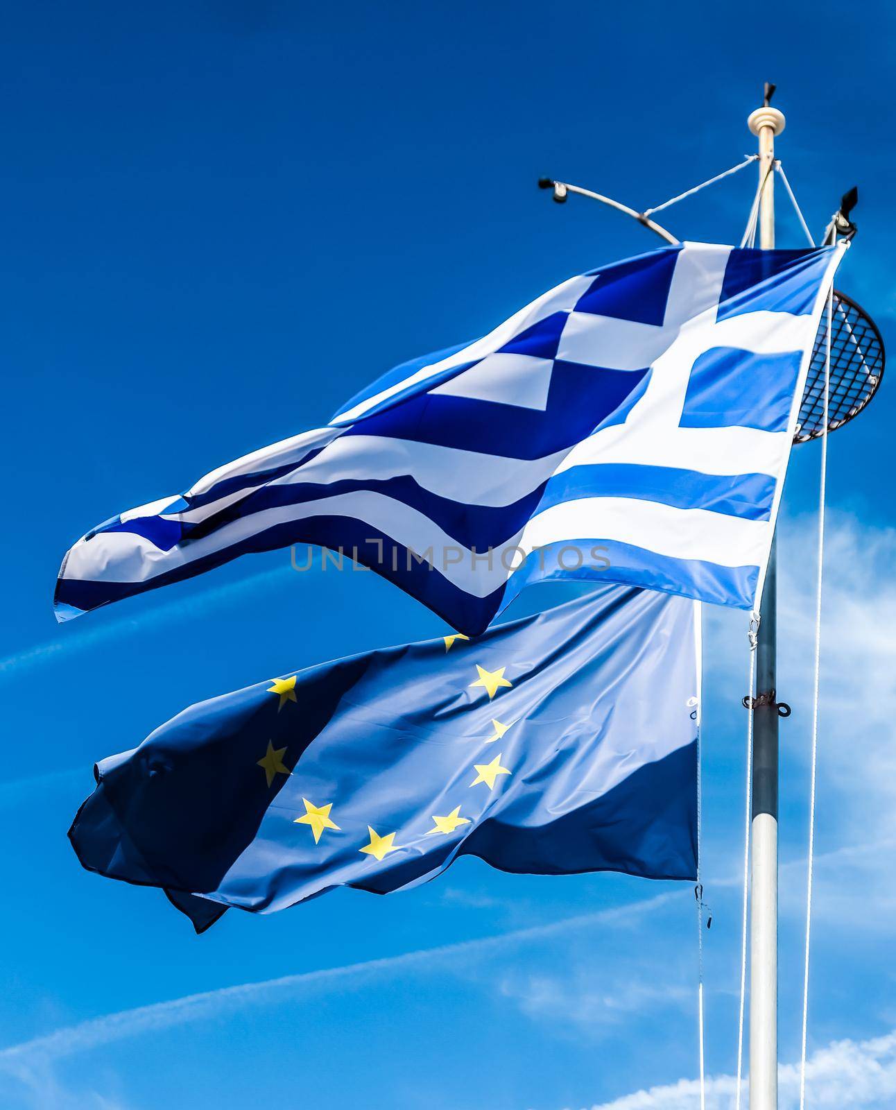 European political news, grexit and nation concept - Flags of Greece and European Union on blue sky background, politics of Europe