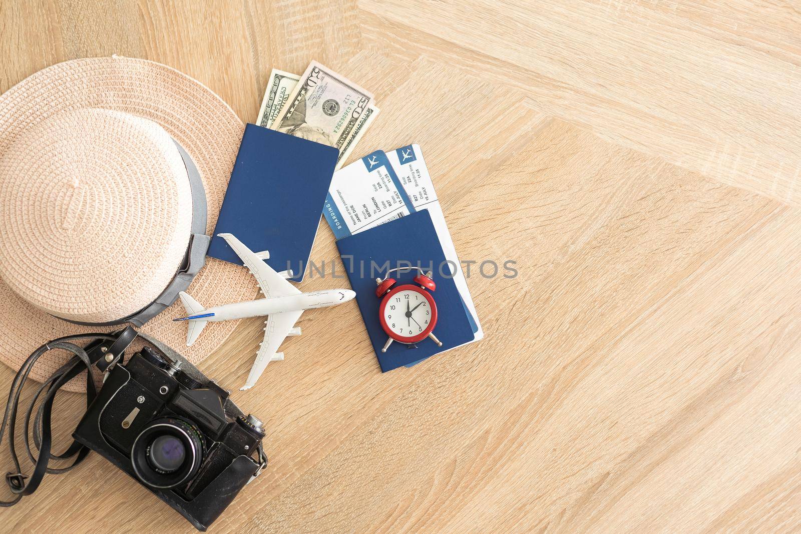 Travel and vacation concept. Trip accessories and items. Airplane toy over passport with airplane tickets and camera.