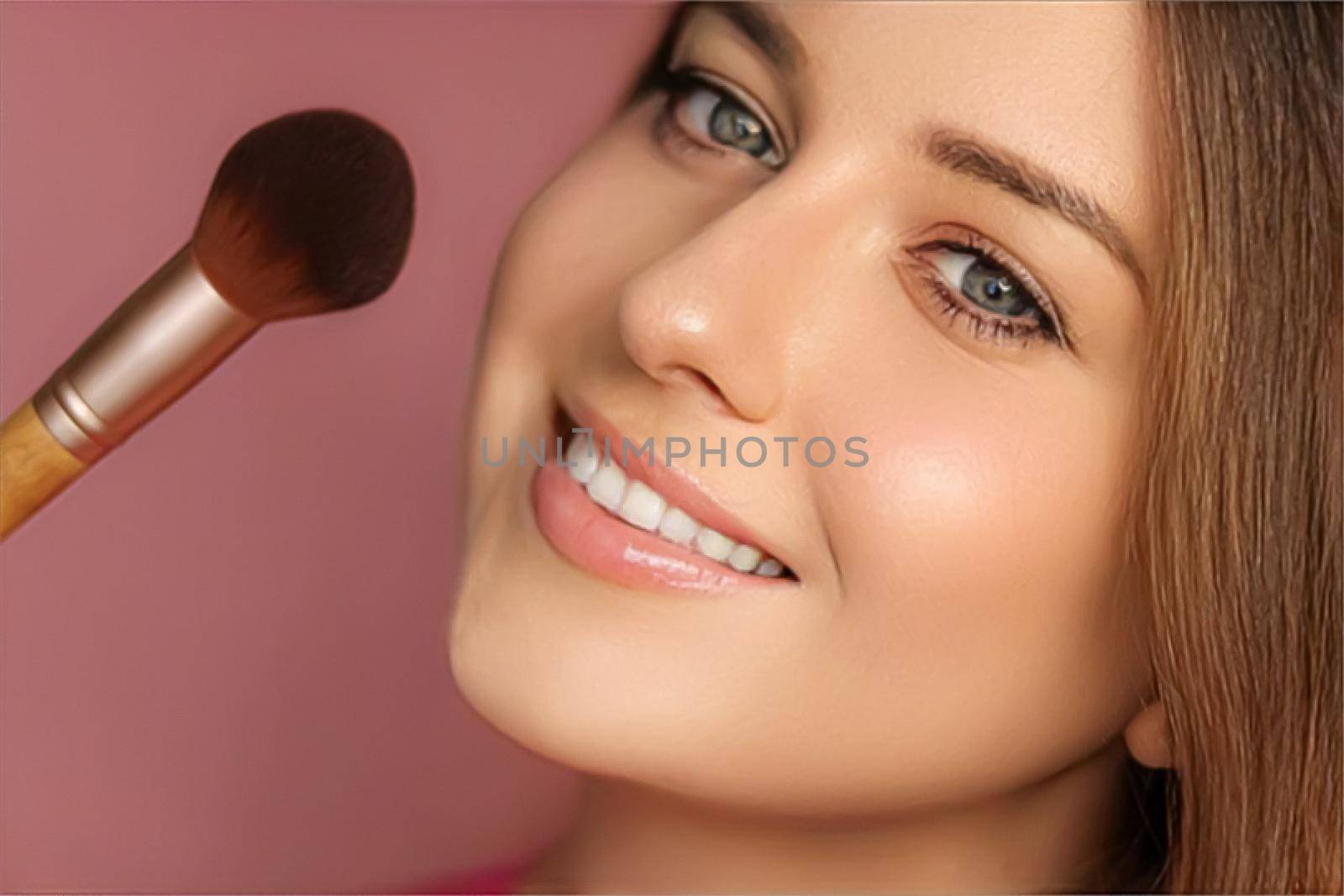 Beautiful young woman applying cosmetic powder product with make-up bamboo brush, beauty, makeup and skincare cosmetics model face portrait on pink background, closeup