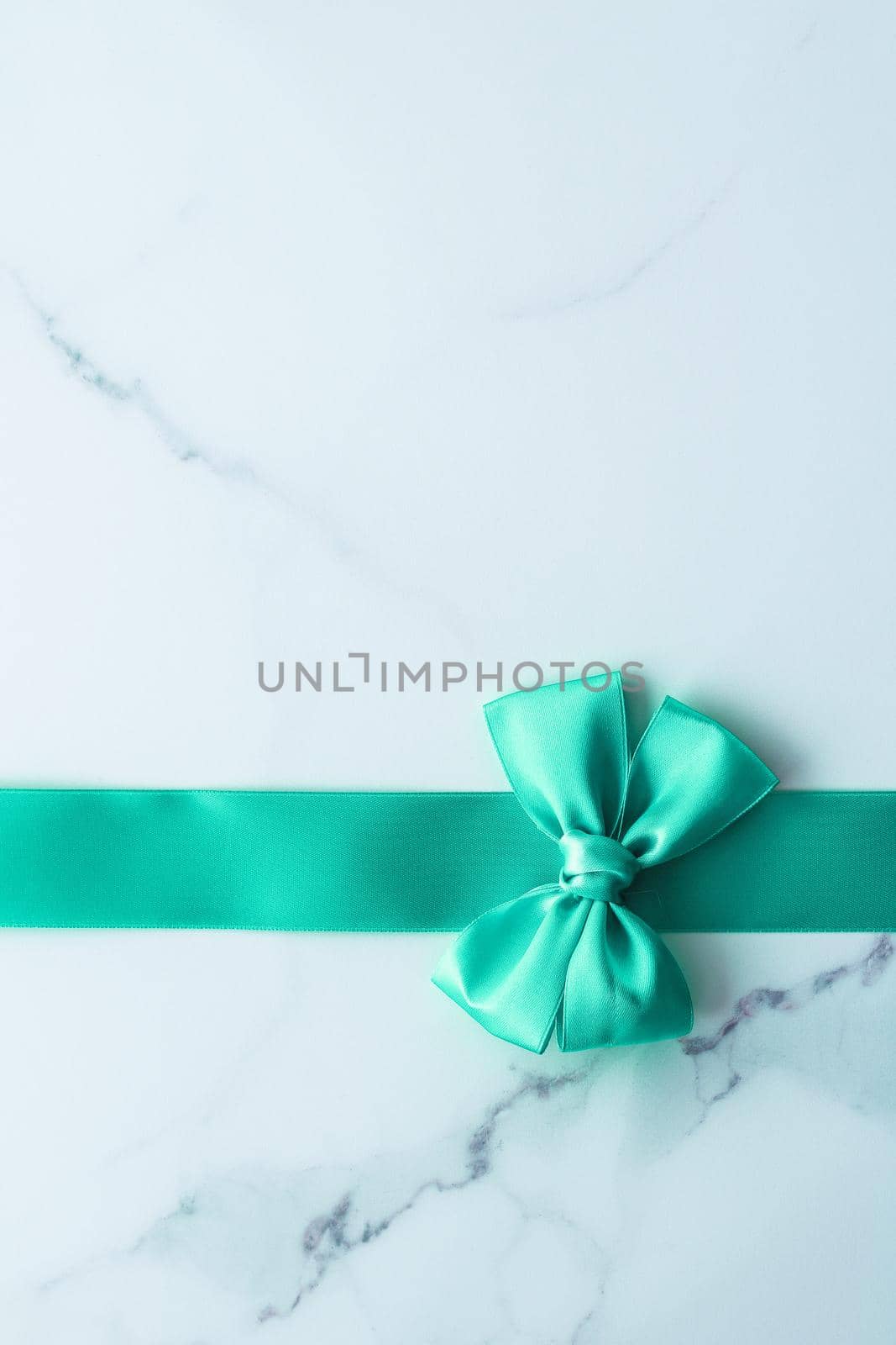 Holiday design, greeting card and vintage gift concept - Green silk ribbon on marble background, top view