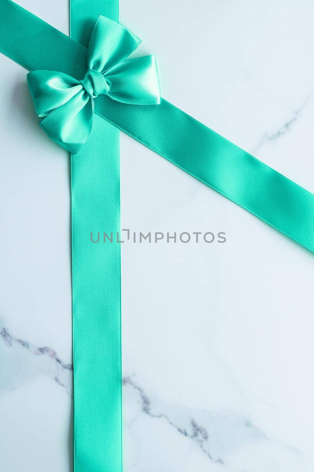 Green silk ribbon on marble background, top view by Anneleven