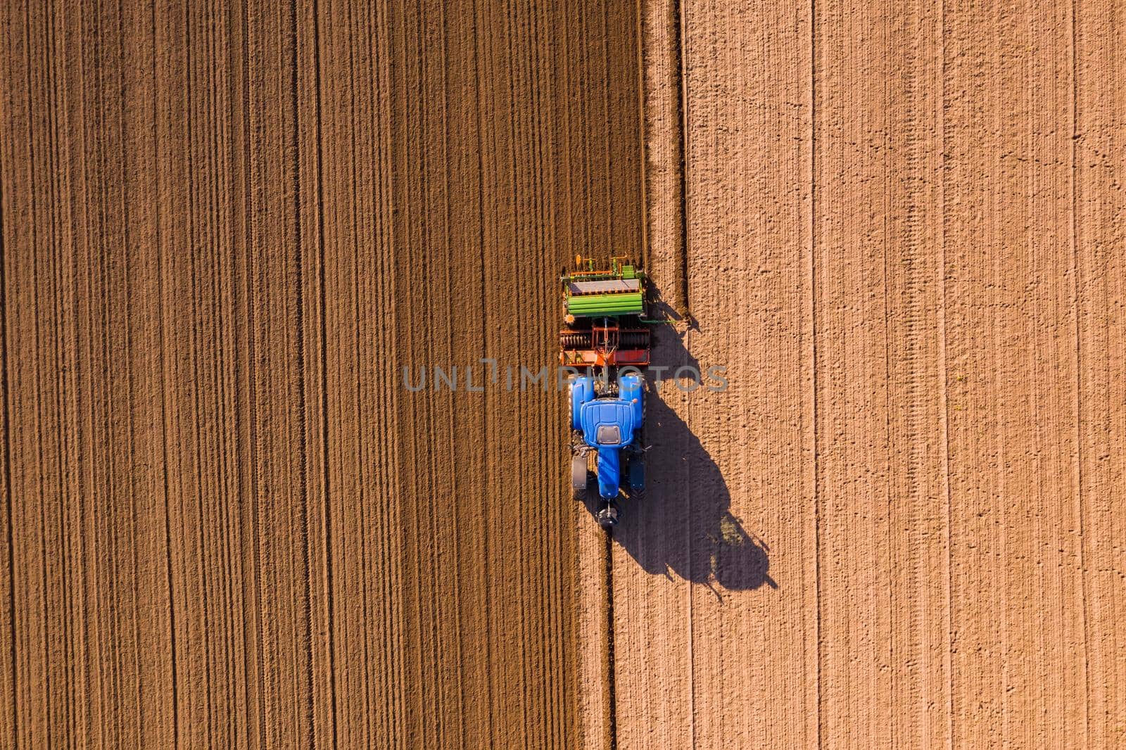 A farmer with a tractor plows a field so that it can lie fallow in winter