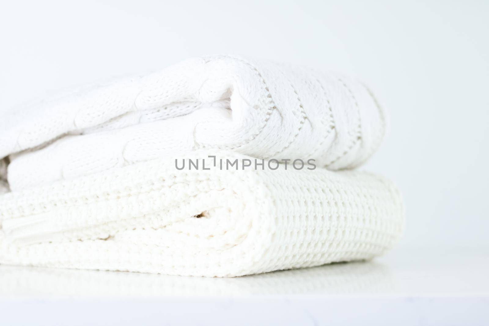 Knitwear, fabric textures and handmade items concept - Warm knitted clothes, soft and white