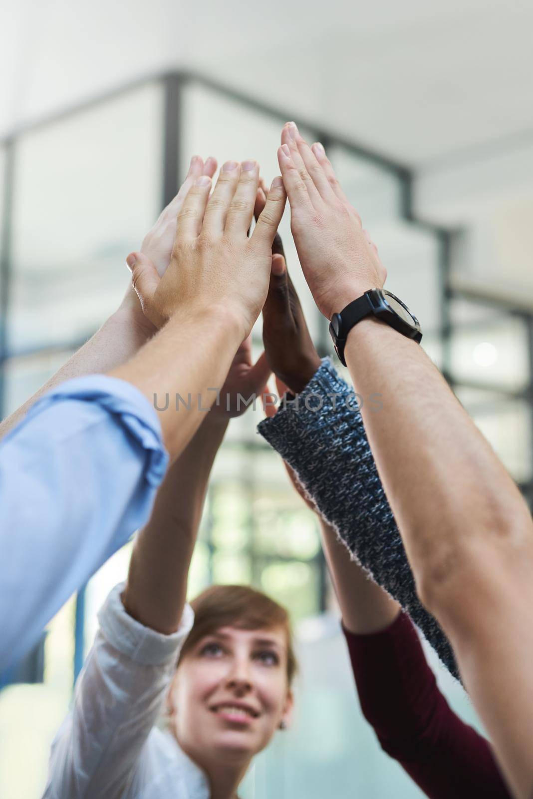 Working together as one. a group of people putting their hands up together in unity