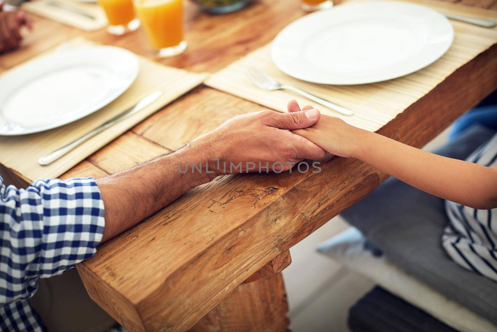 This family has its foundations in faith. an unidentifiable family praying together before enjoying a meal at the table