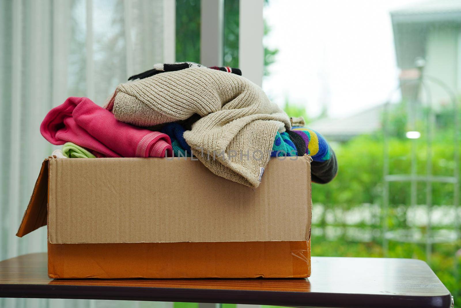 Clothes donations in cardboard box for volunteer.