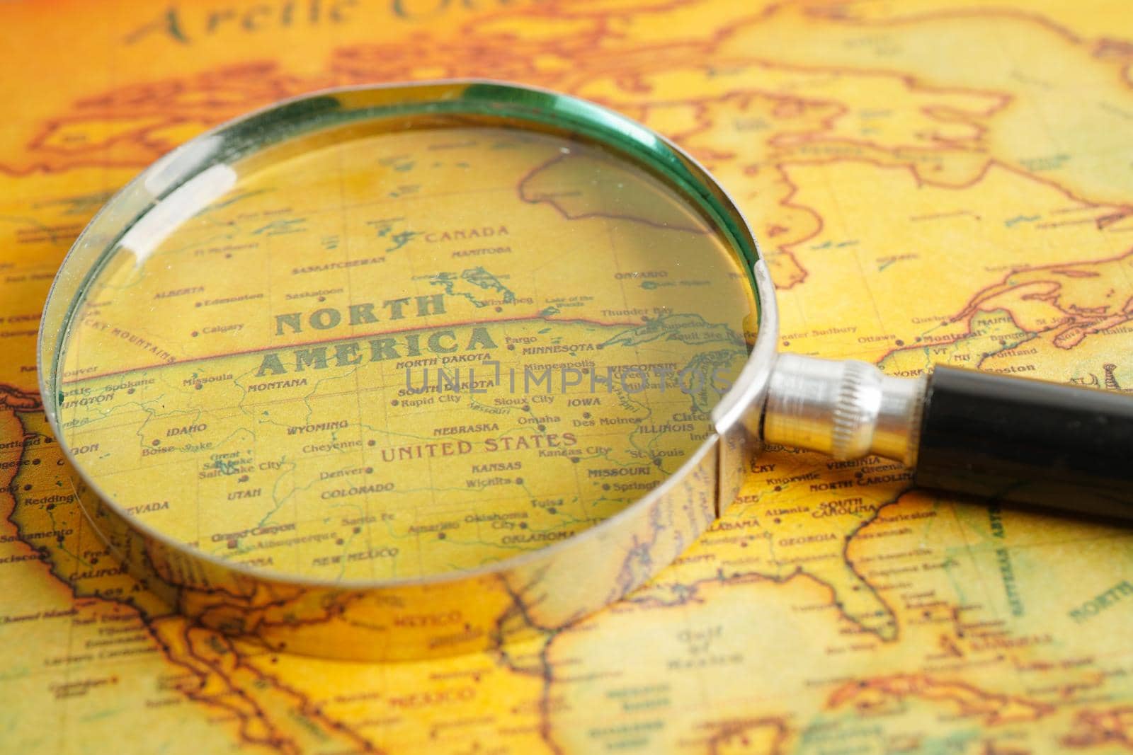 Bangkok, Thailand - December 15, 2021 Magnifying glass on ancient vintage world map.