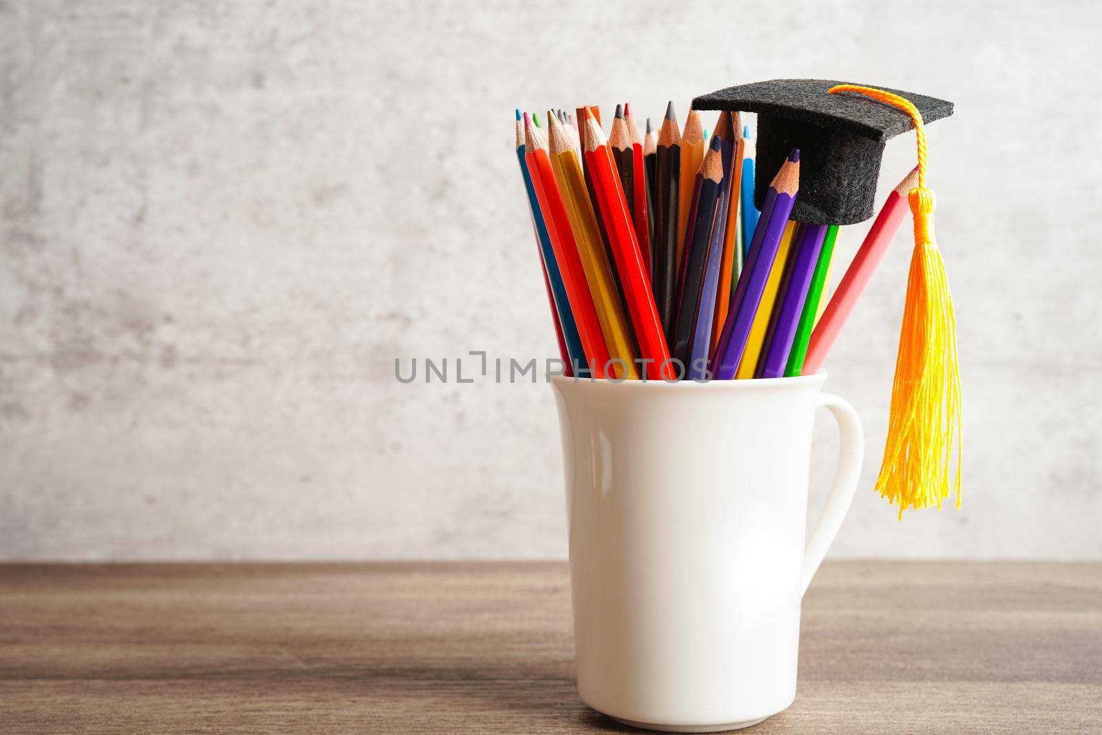 Graduation hat with colorful pencils on book with copy space, learning university education concept.