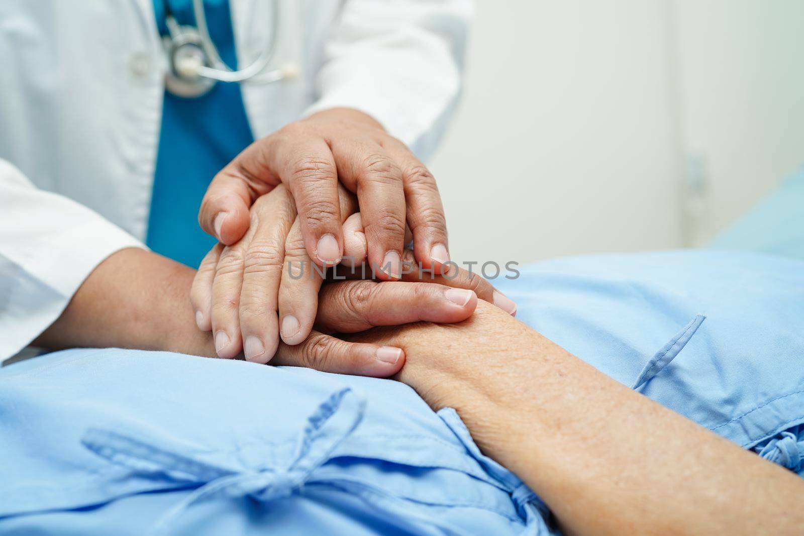 Doctor holding hands Asian elderly woman patient, help and care in hospital.