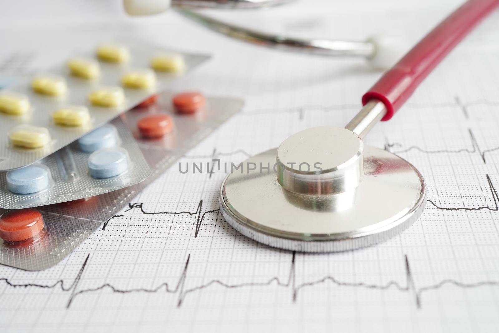 Stethoscope on electrocardiogram (ECG) with drug, heart wave, heart attack, cardiogram report.