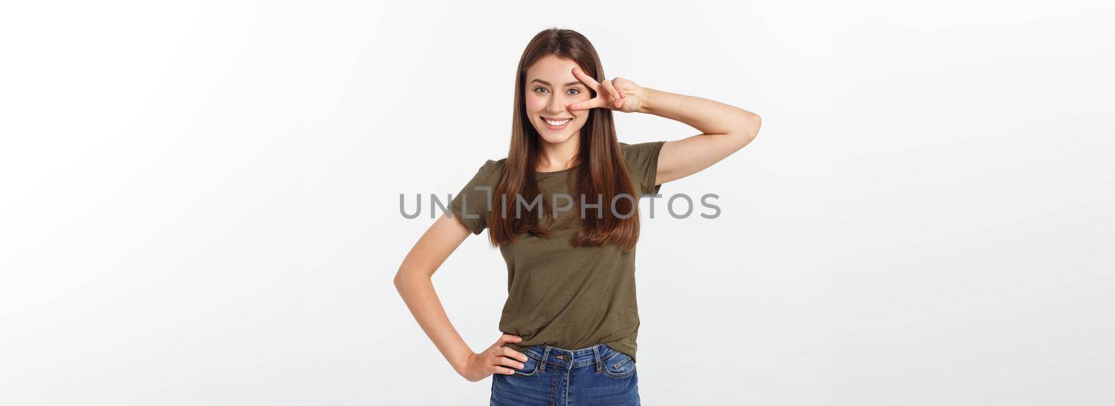 Young woman showing two fingers, positive or peace gesture, on white