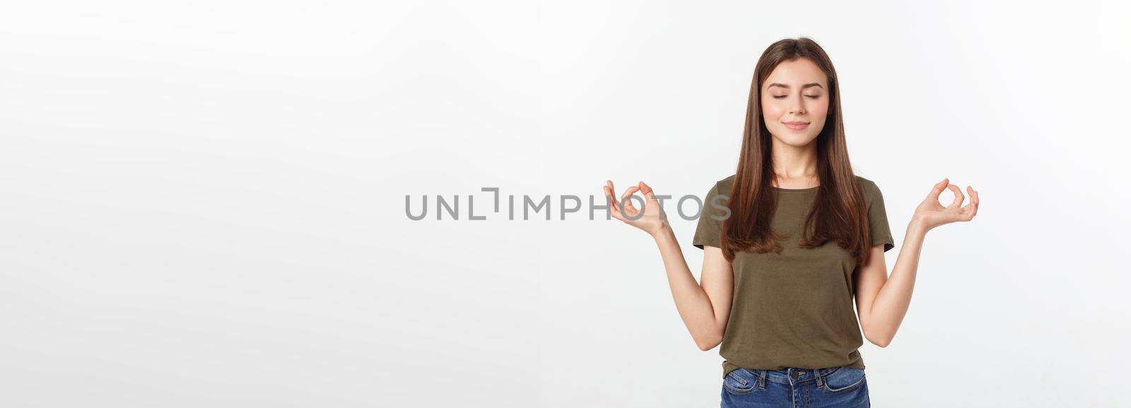 Beautiful young woman in yoga position and meditating isolated over gray background.