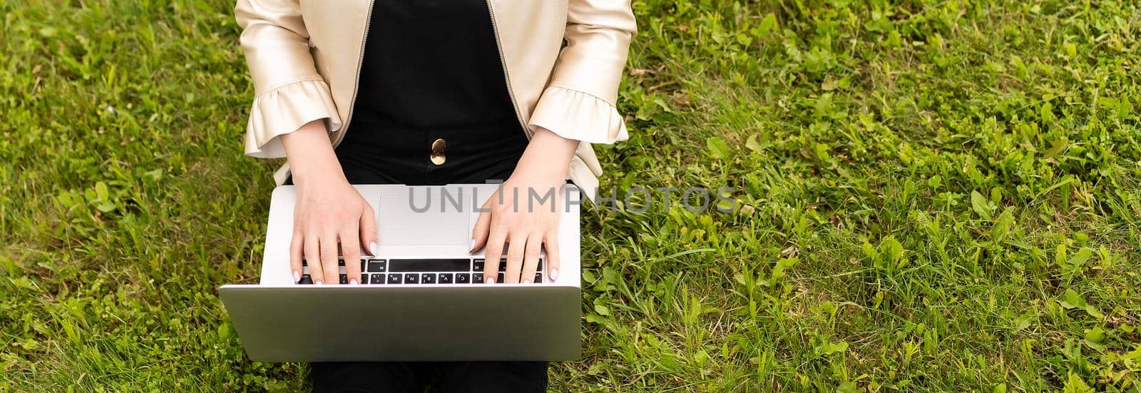 Woman with laptop relaxing in park by Andelov13