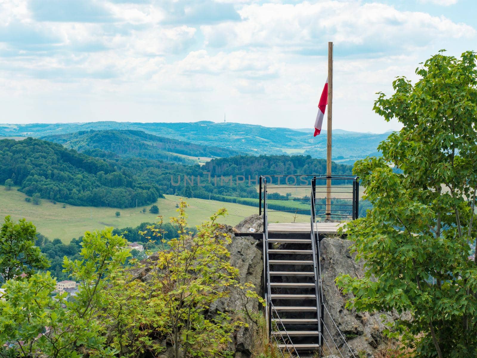 Flag of Ceska Kamenice town flying in the wind on wooden pole. Ceska Kamenice town symbol, north of Czech Republic