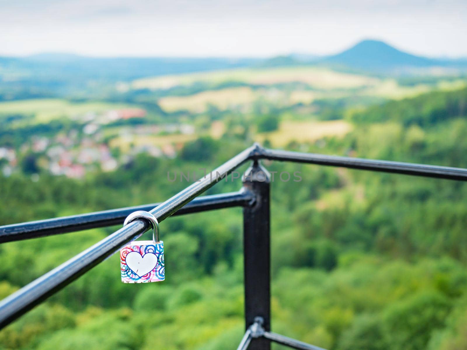 Colorful love padlock locked on bridge bar. Symbol of marriage or eternal love by rdonar2