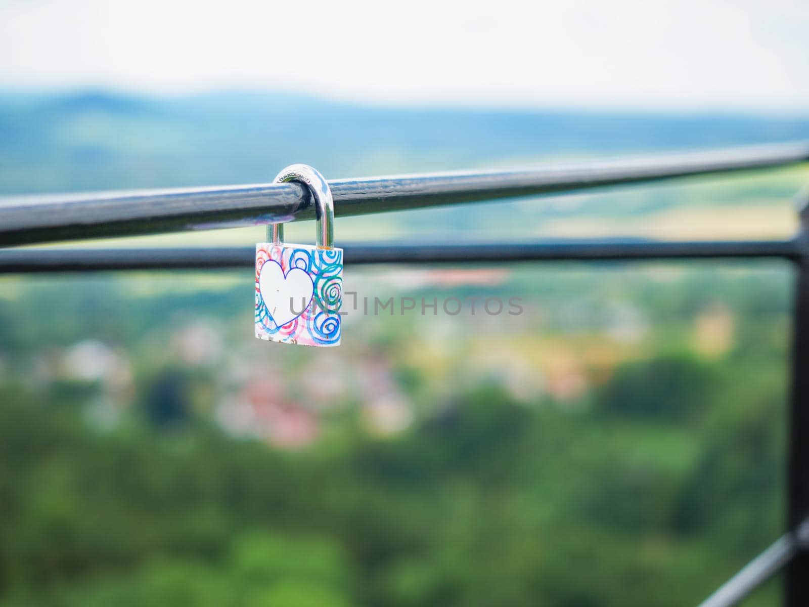 Locked lock hangs on the metal fence. Symbol of love in the park by rdonar2