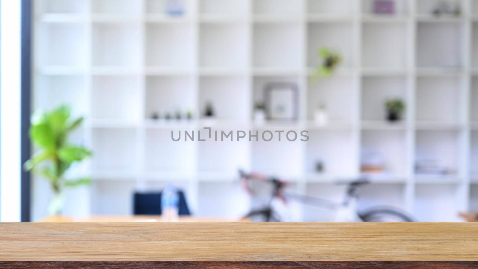 Wood table with blurred bookshelf in background. For montage product display.