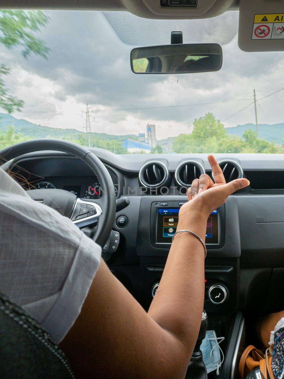Beautiful business lady driving her car a cloudy day in summertime