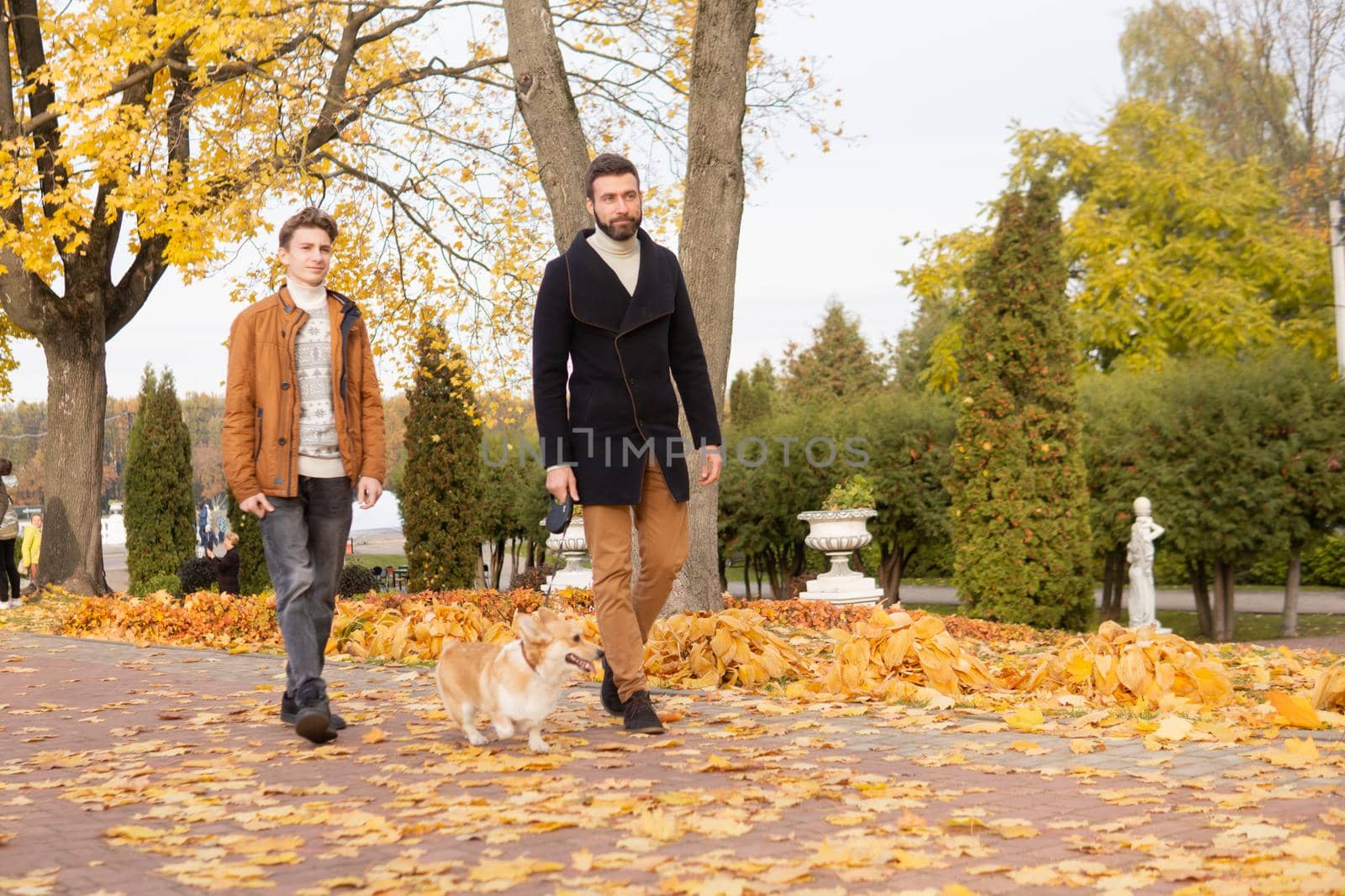 Father and son with a pet on a walk in the autumn park by Annu1tochka