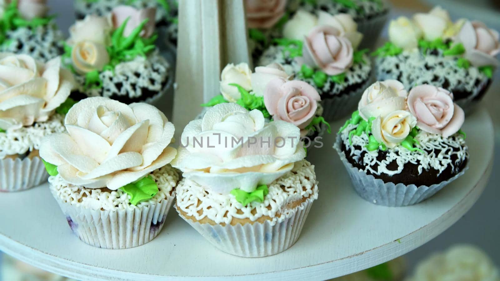 close-up, a variety of delicious desserts, cupcakes, cream cakes, whipped cream, flowers made with cream. festive decor, sweet bar, confectionery masterpieces, treats. High quality photo