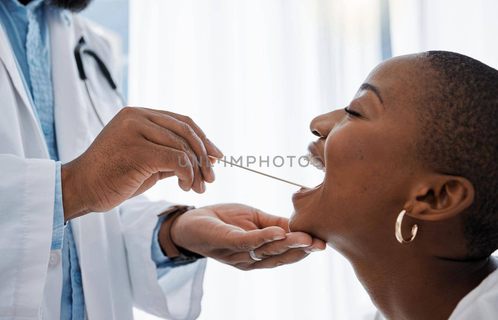 Doctor, otolaryngologist or dentist with a medical instrument checking the throat for tonsils or oral cancer. Health, healthcare worker and wellness with an ent specialist examining a black woman.