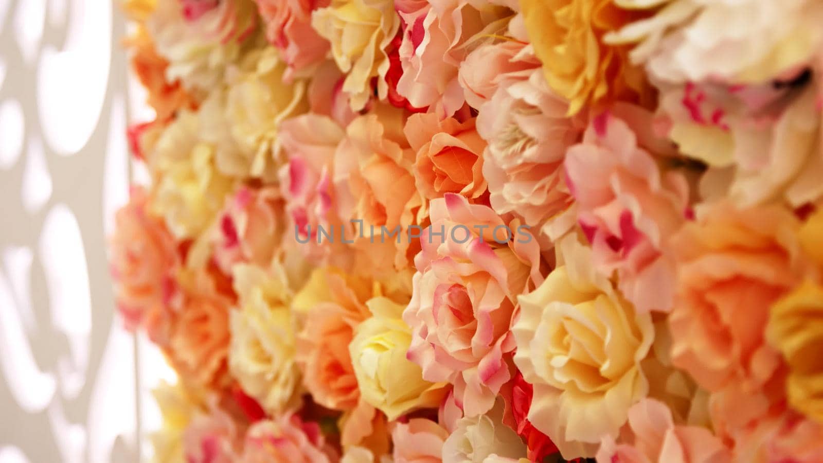 close-up, wedding decor, festive decoration with buds of roses, beautiful wall of buds of orange, peach roses. High quality photo
