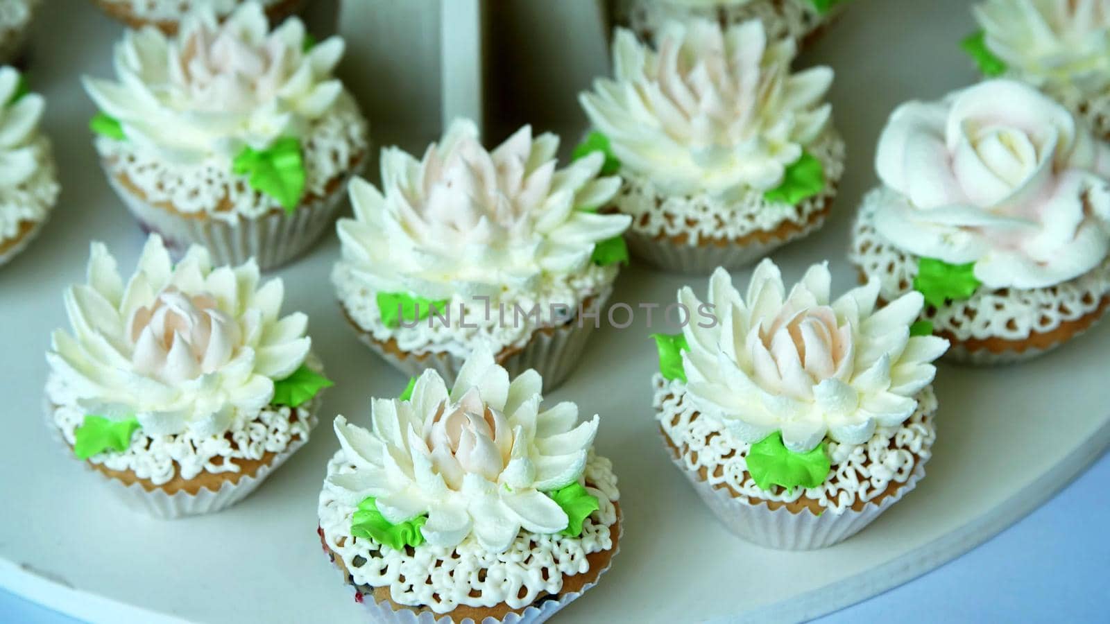 close-up, a variety of delicious desserts, cupcakes, cream cakes, whipped cream, flowers made with cream. festive decor, sweet bar, confectionery masterpieces, treats. High quality photo