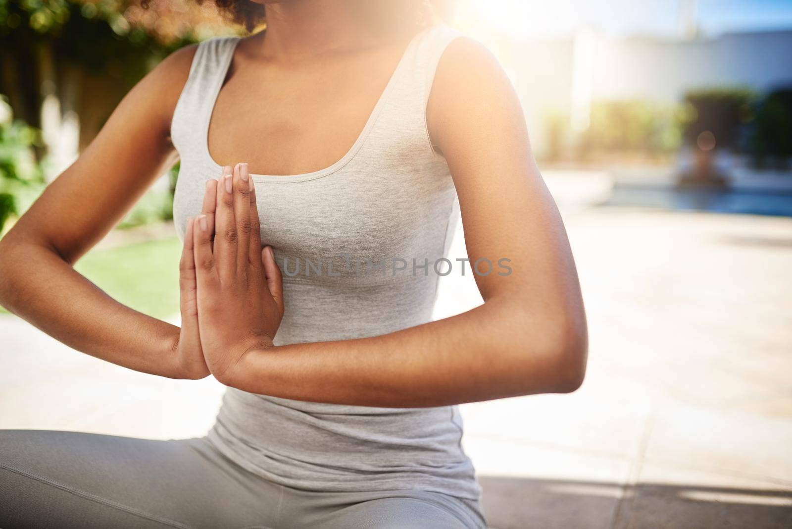 Keeping to her yoga routine. a sporty young woman practicing yoga outdoors. by YuriArcurs