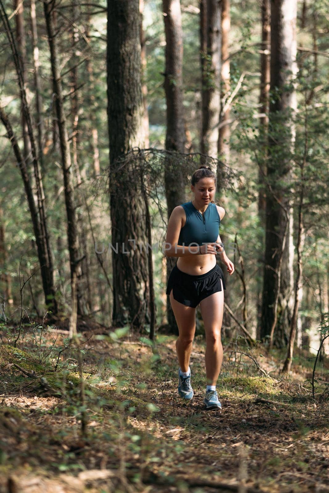 Fitness woman trail runner running on sunrise in summer forest by apavlin