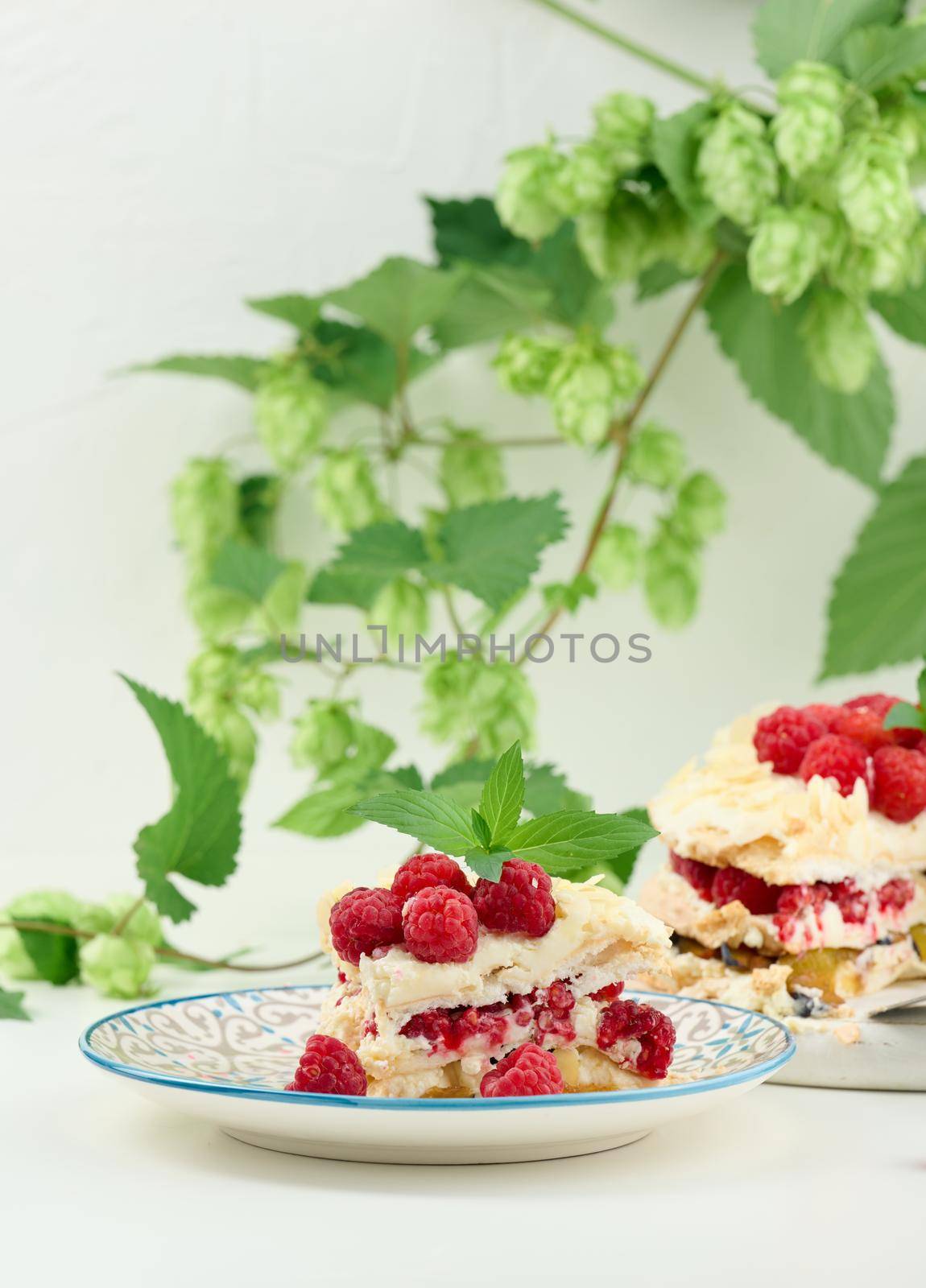 Round meringue pie with fresh raspberries on a white background, Pavlova dessert