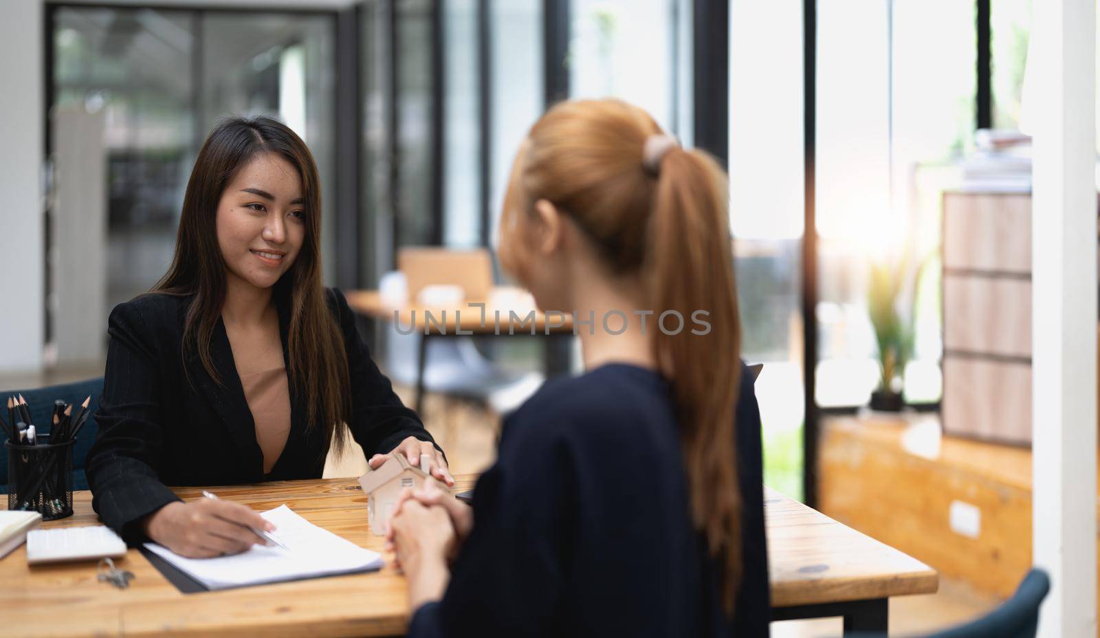 real estate agent holding house key to his client after signing contract,concept for real estate, moving home or renting property.