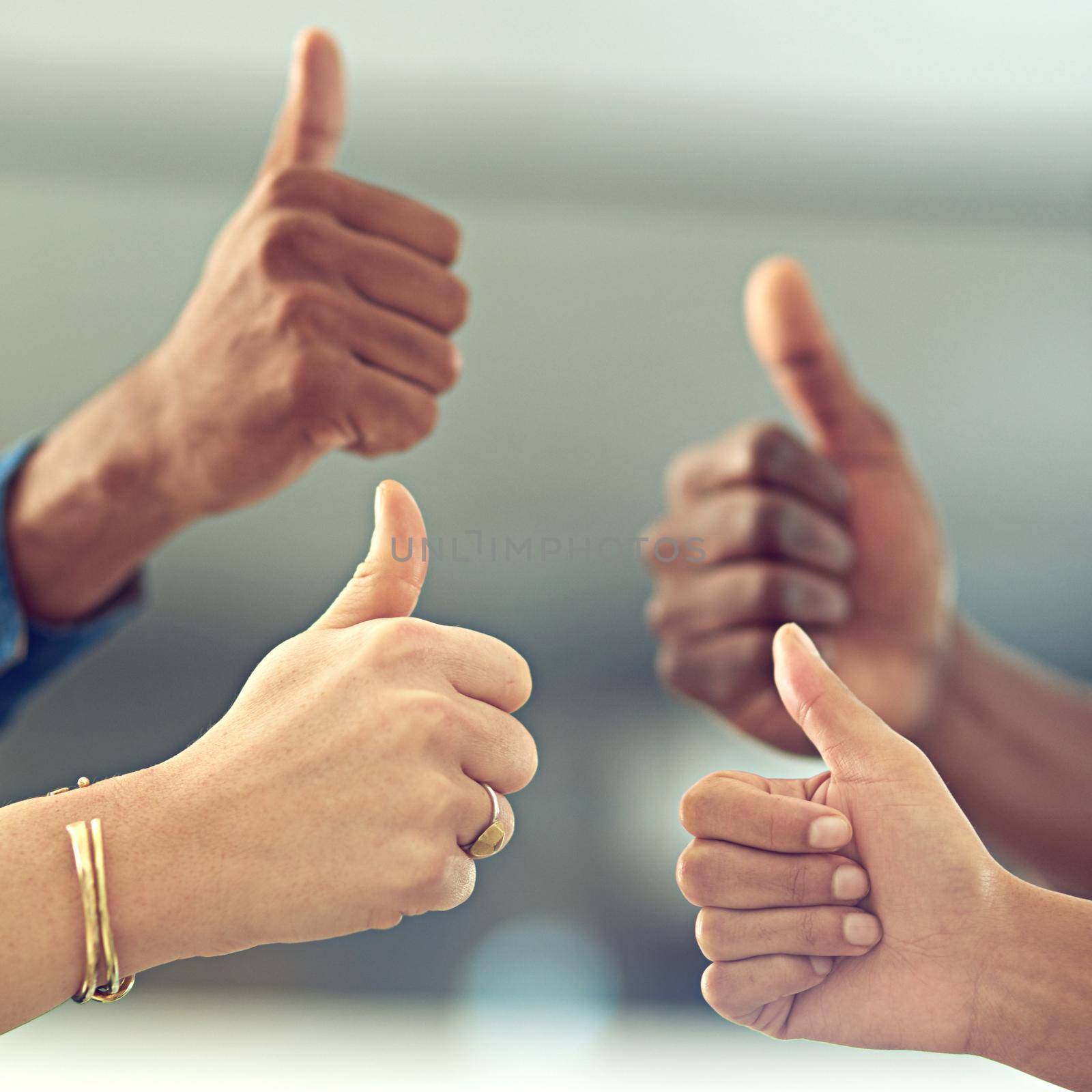 That was amazing. Closeup shot of a group of businesspeople giving thumbs up together. by YuriArcurs