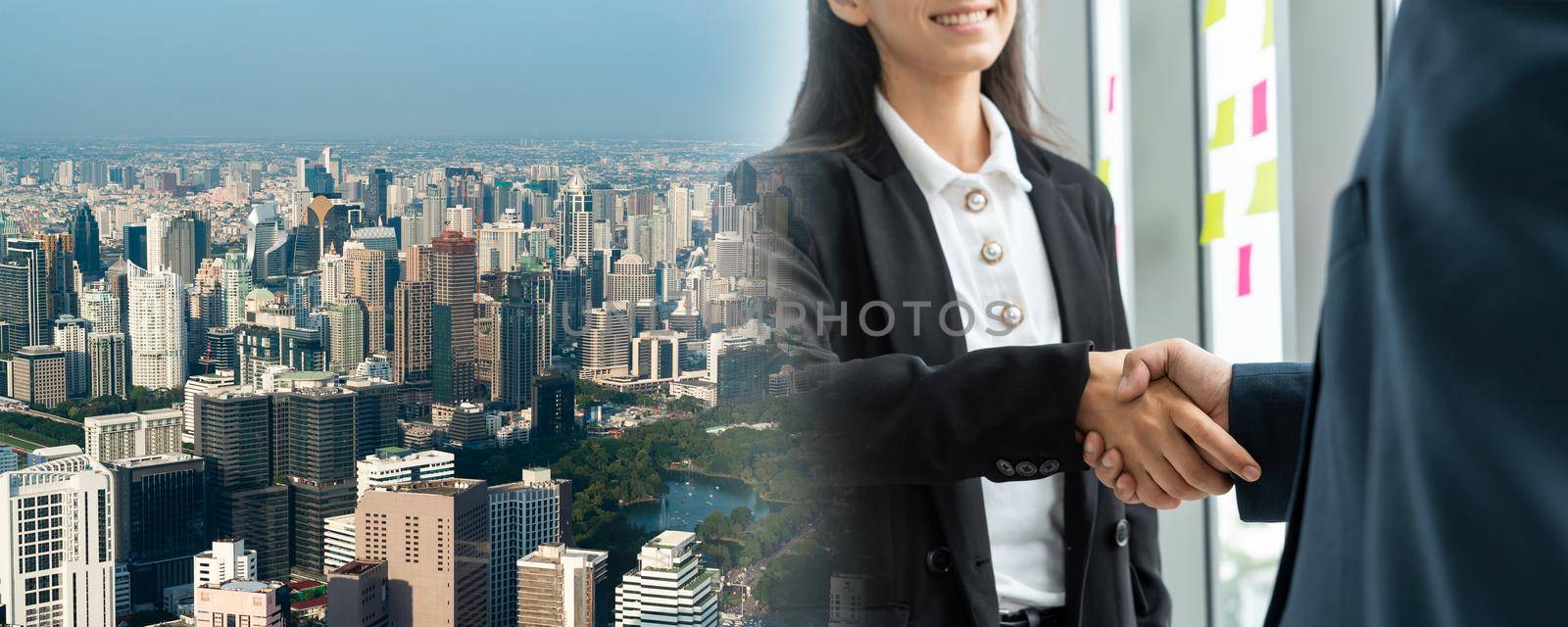 Business people handshake in corporate office in widen view showing professional agreement on a financial deal contract.