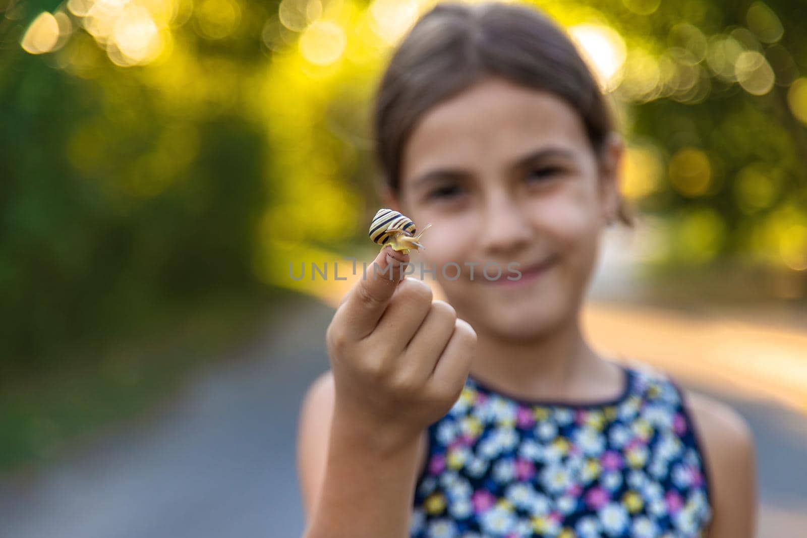 A child is studying a snail in the park. Selective focus. Nature.