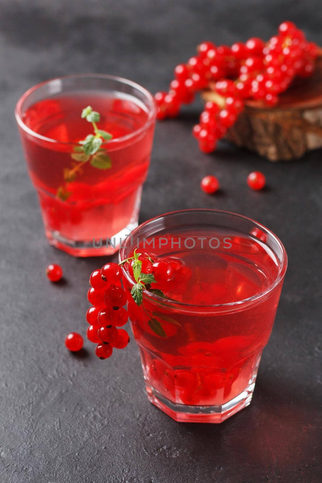 Redcurrant vitamin drink in a glass on a black background with currant berries. healthy eating