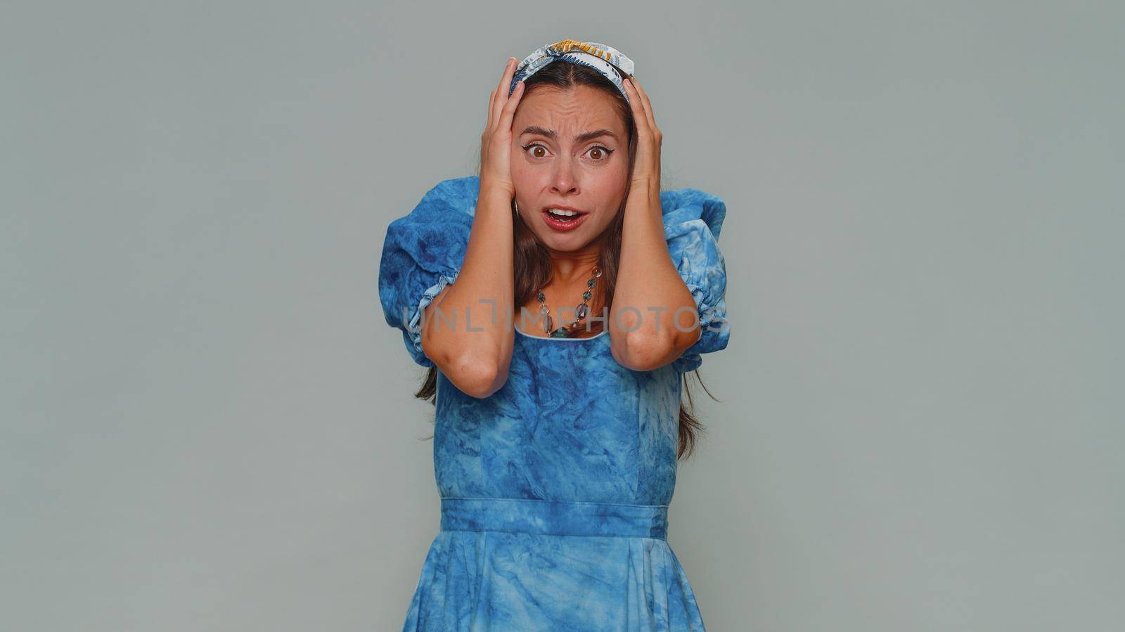 Stressed depressed woman terrified about danger problems, suffering phobia, anxiety disorder, expresses fear, waving no, insecure, stress, panic. Adult girl isolated on gray studio background indoors