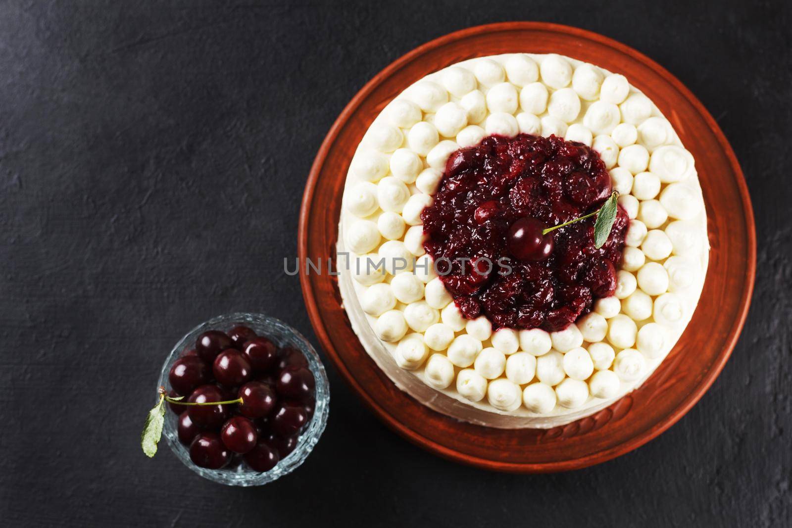 Biscuit cake, cherry souffle with cream cheese and cherry confiture on a black background. copy space by lara29