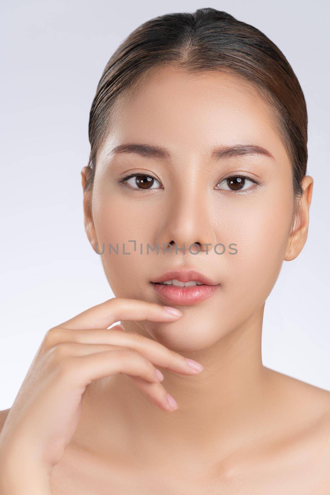 Close up portrait of gorgeous young girl posing beauty gesture with healthy clear skin and soft makeup. Cosmetology and beauty concept.