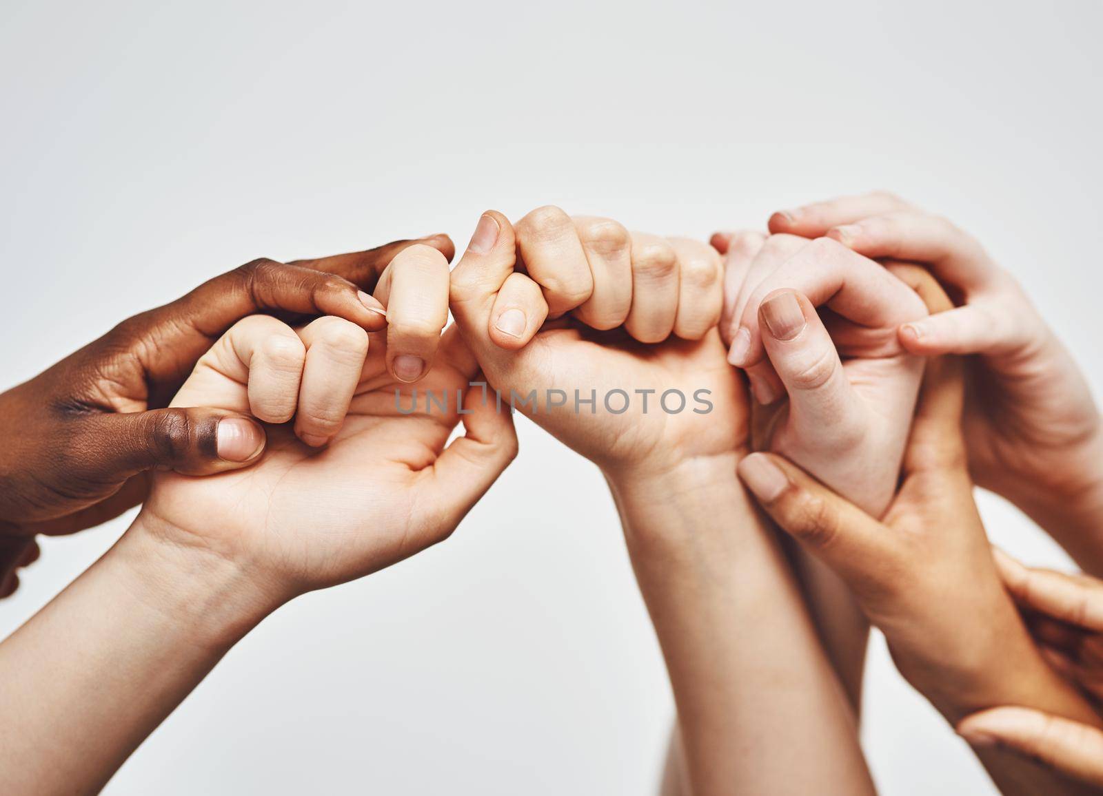 Hold on just a little longer. a group of hands holding onto each other against a white background. by YuriArcurs
