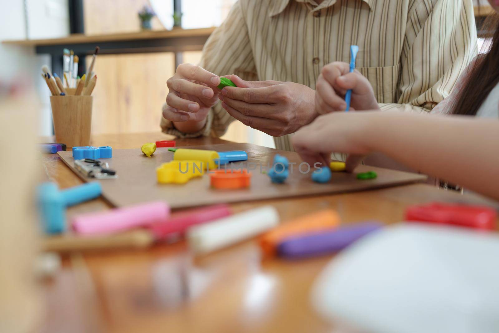 Adorable little girl and father playing with colorful plasticine. Handmade skills training.