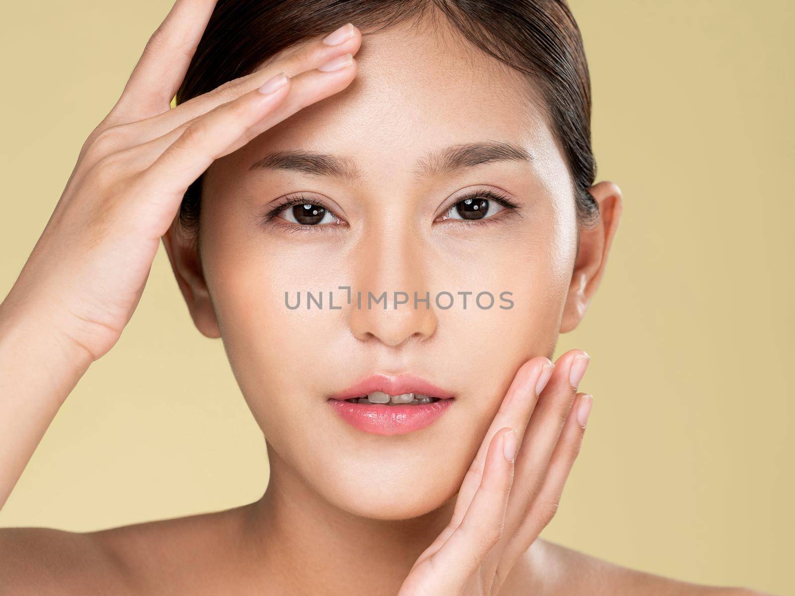 Closeup ardent young woman with healthy clear skin and soft makeup looking at camera and posing beauty gesture. Cosmetology skincare and beauty concept.