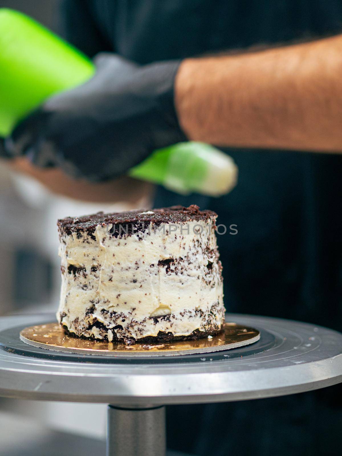 professional baker decorating a chocolate and cream cake with salty caramel