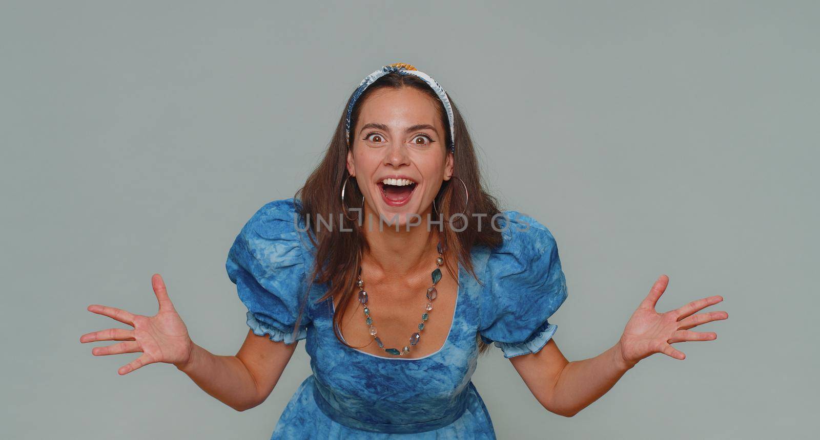 Oh my God, Wow. Excited amazed woman looking surprised at camera with big eyes, shocked by sudden victory game winning, lottery goal achievemen, good news. Adult girl on gray studio background indoor