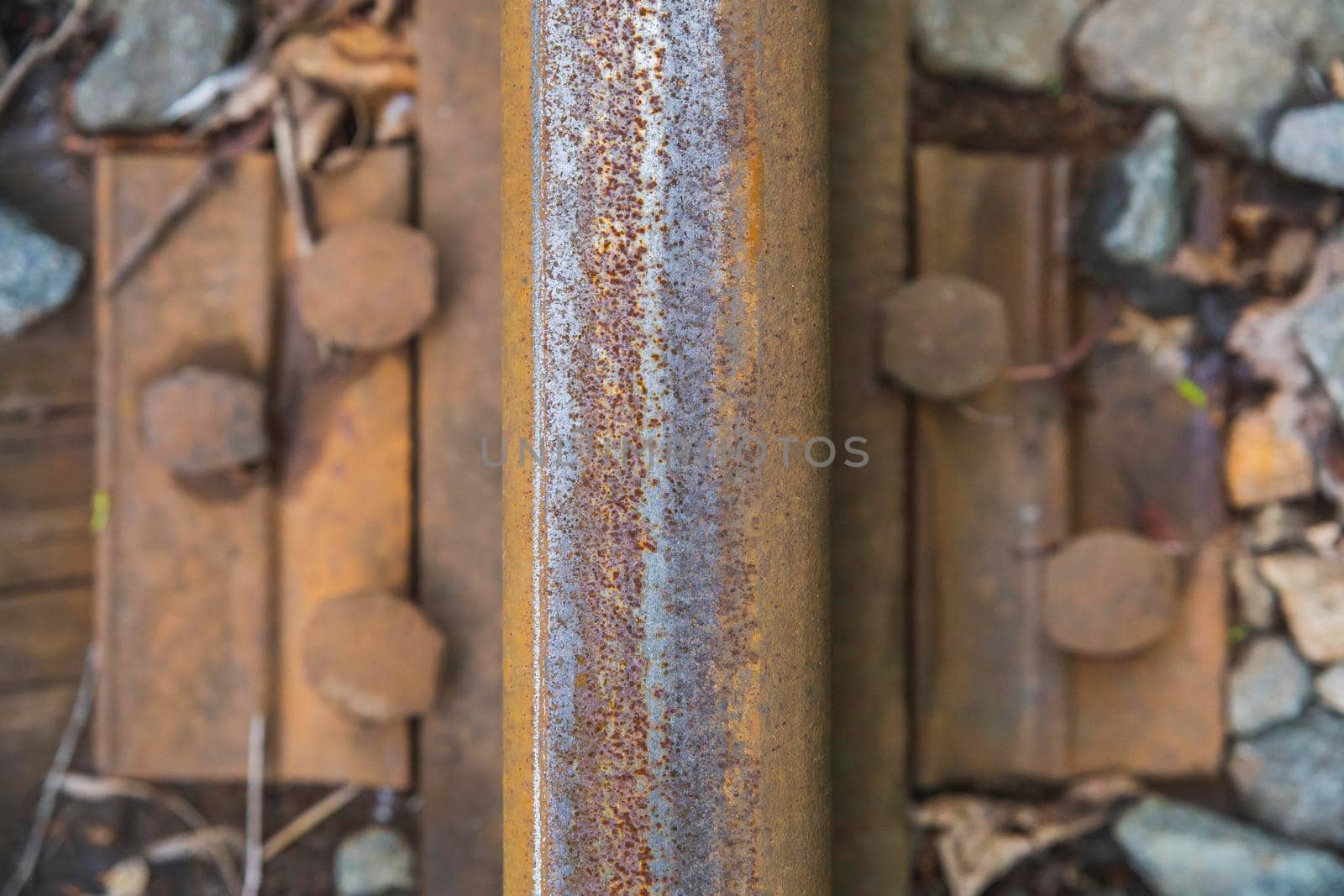 old rusty rail close-up on a rotten wooden railway sleeper . High quality photo