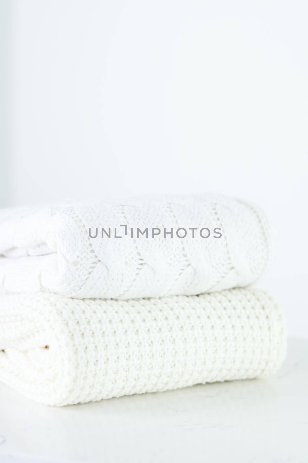 Knitwear, fabric textures and handmade items concept - Warm knitted clothes, soft and white