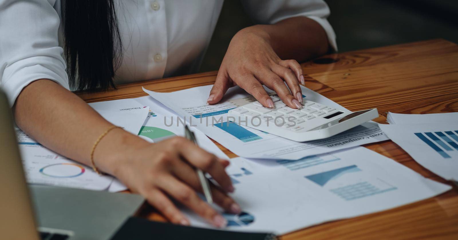 Accountant woman hand press on calculator for make financial report or company's profit monthly at desk , bookkeeper job and work from home concept.