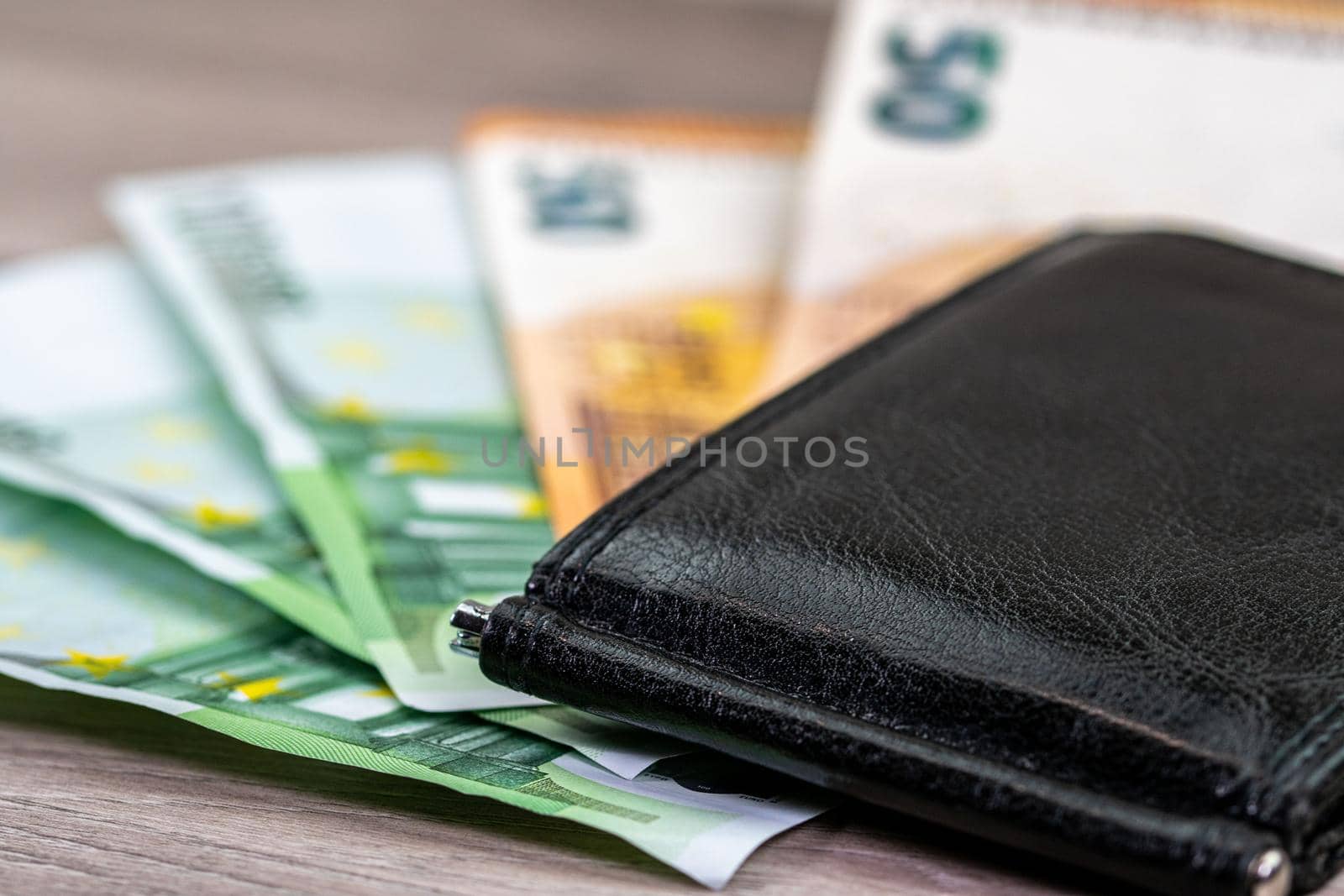 50 and 100 euro banknotes with wallet on wooden top