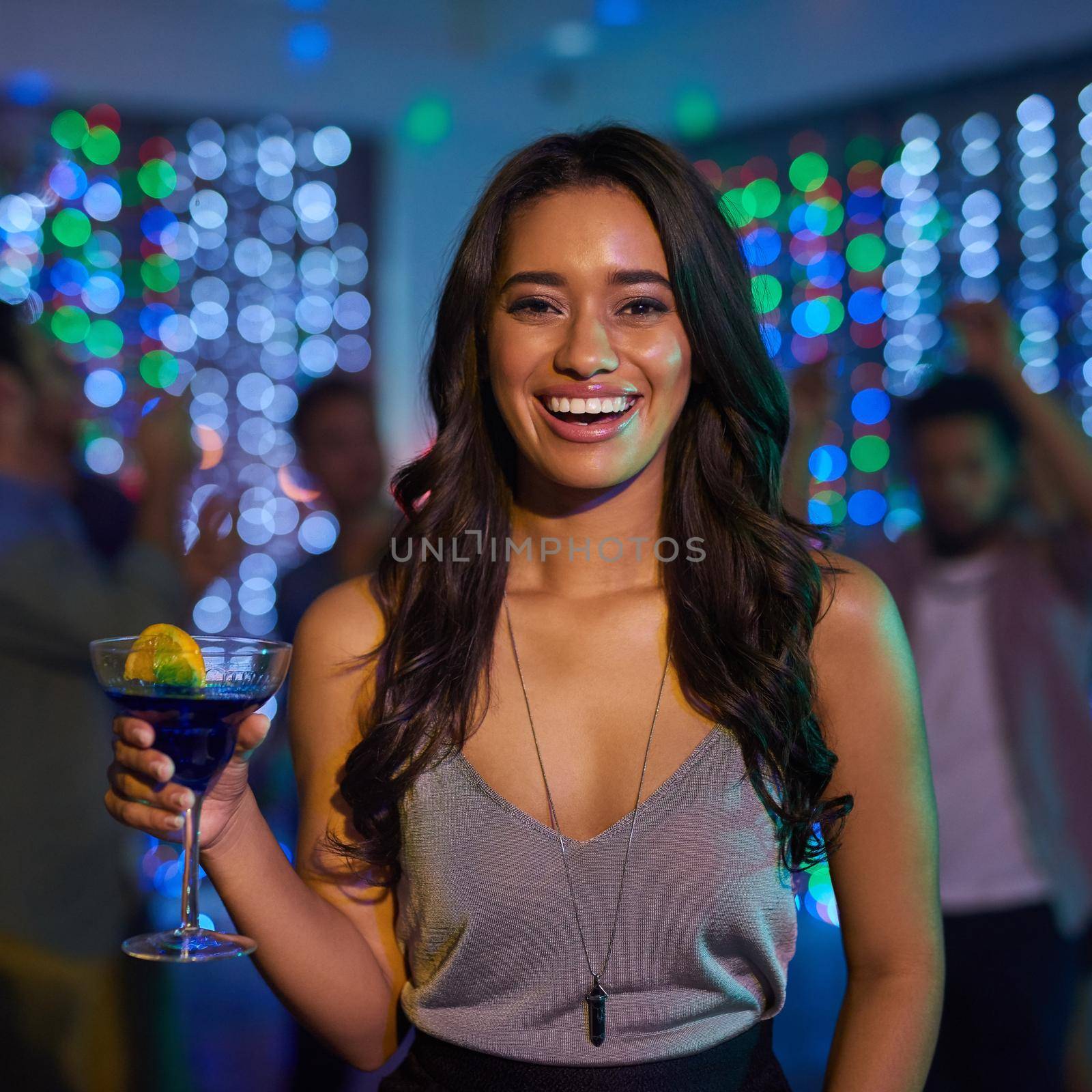 Can you tell how excited I am for the weekend. Portrait of an attractive young woman having a drink while partying in a club. by YuriArcurs