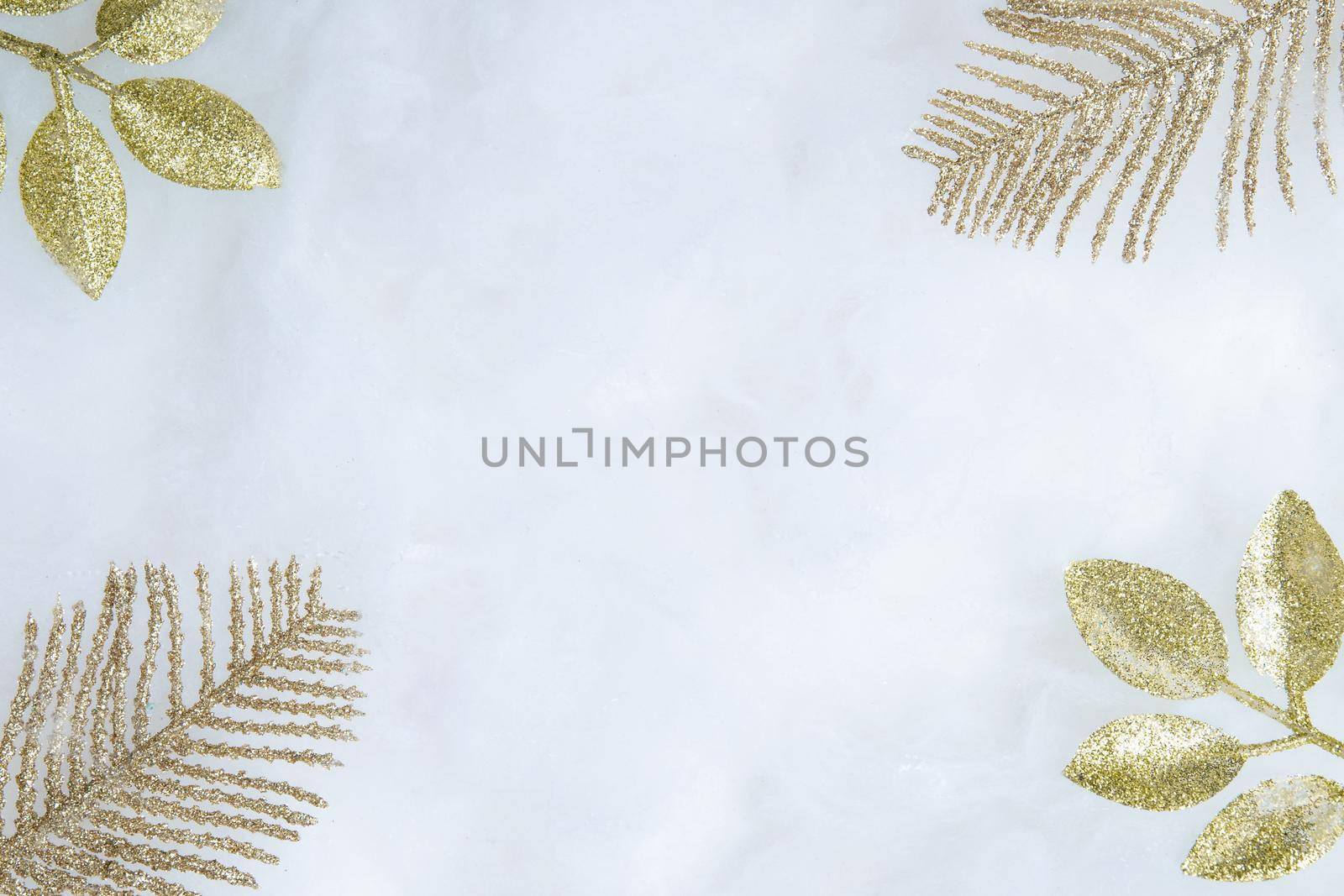 Decorative golden twigs in glitter on the snow with copy space flat lay. Christmas and New year background top view