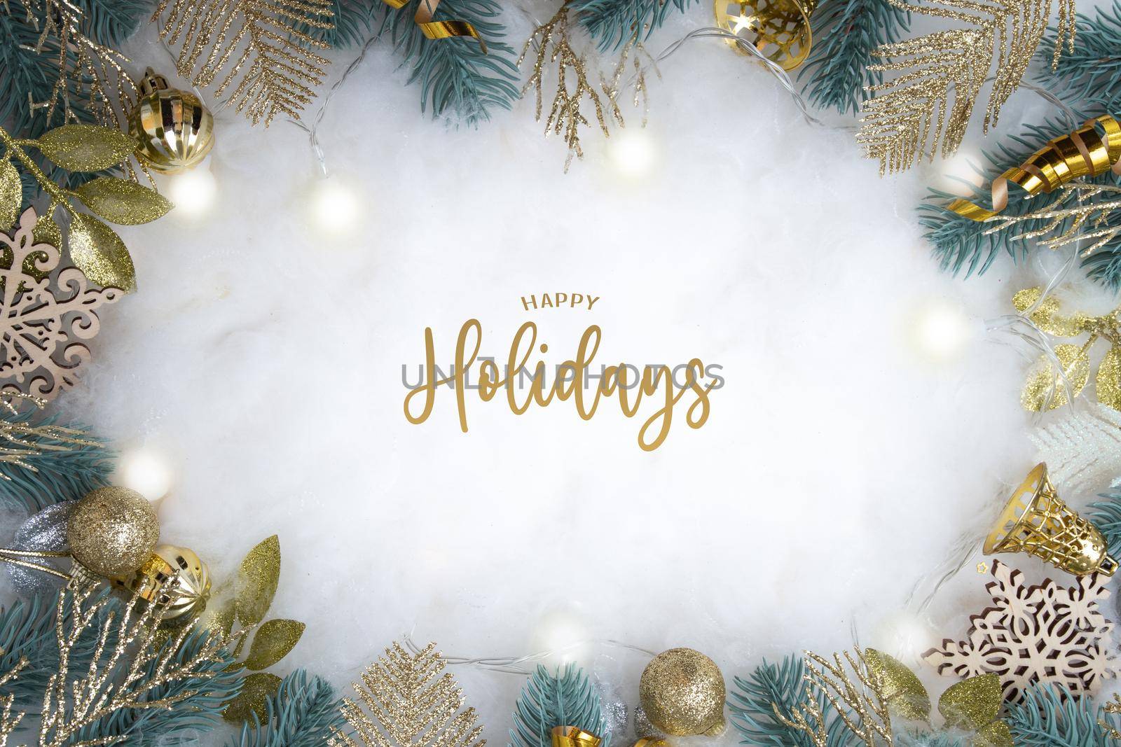 Happy Holidays text with frame made of Christmas decorations on a snowy background flat lay top view